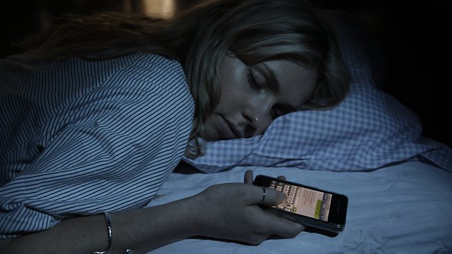 Mujer joven durmiendo con iphone en mano